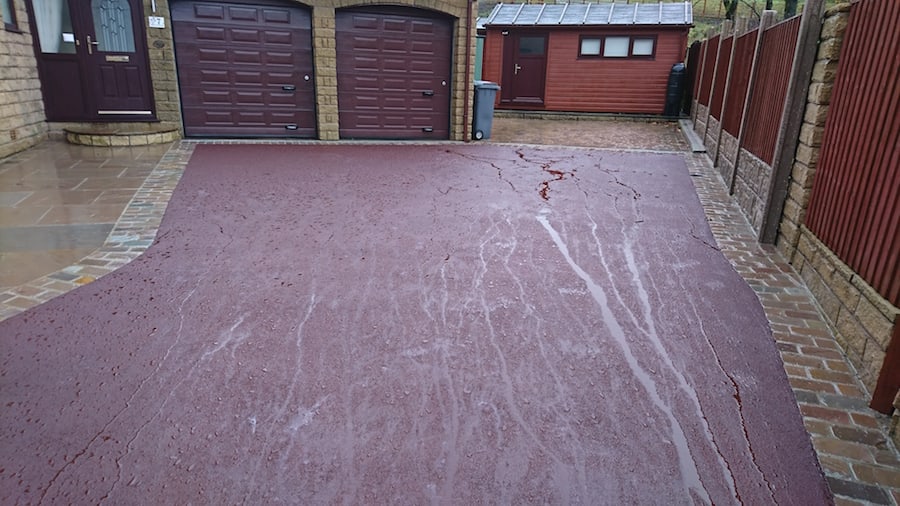 red tarmac drive after looking up to garage doors